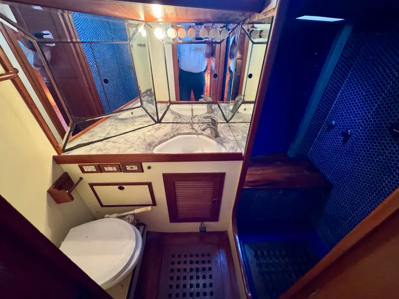 Slide: The Image of Bathroom interior of 1983 Tayana 52 Aft Cockpit yacht with mirrored cabinets and wooden accents. - 13