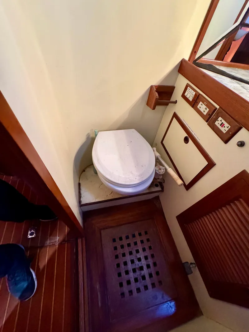 Slide: The Image of 1983 Tayana 52 Aft Cockpit yacht bathroom with toilet and wooden flooring. - 16