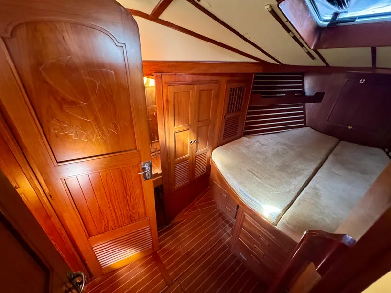 Slide: The Image of Cozy wooden cabin interior of 1983 Tayana 52 Aft Cockpit sailboat with bed and storage. - 17