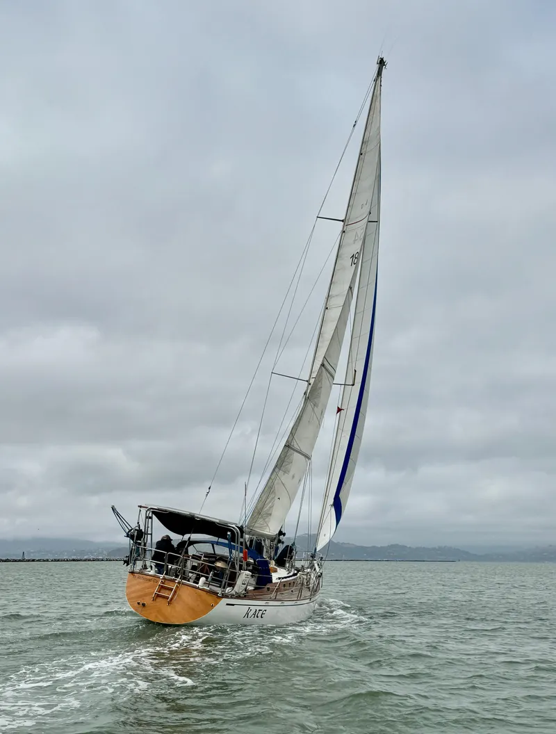 Slide: The Image of 1983 Tayana 52 Aft Cockpit sailboat navigating on a cloudy day. - 2