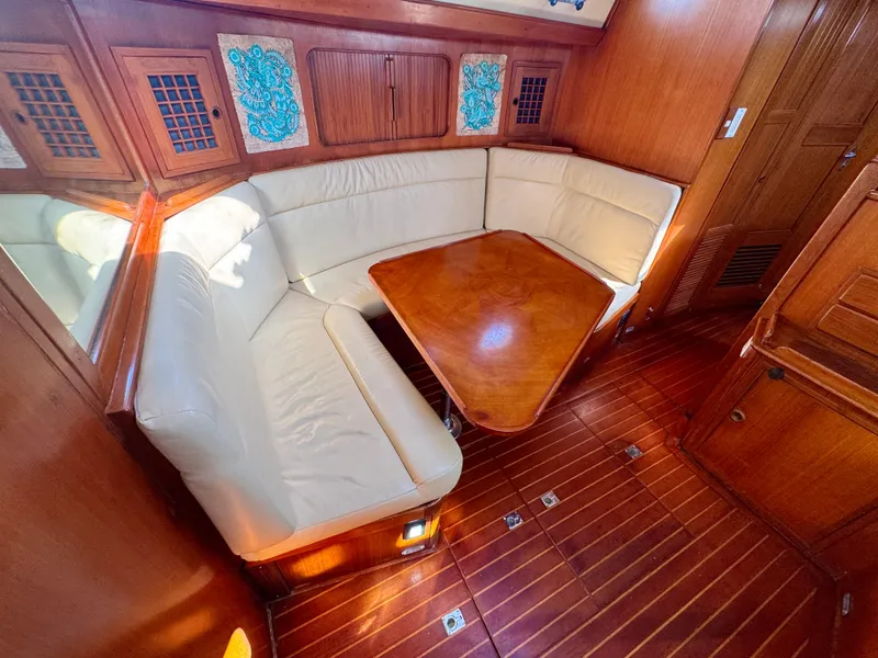 Slide: The Image of 1983 Tayana 52 Aft Cockpit interior with wooden table and cream seating. - 21