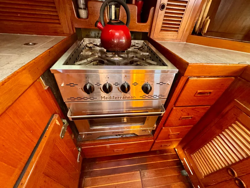 Slide: The Image of Stainless steel stove with red kettle in 1983 Tayana 52 Aft Cockpit yacht kitchen. - 24