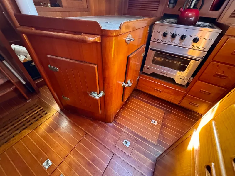 Slide: The Image of Wooden galley interior of 1983 Tayana 52 Aft Cockpit yacht with stove and cabinetry. - 25