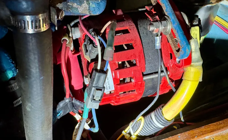 Slide: The Image of Engine compartment of 1983 Tayana 52 Aft Cockpit with visible wiring and alternator. - 32