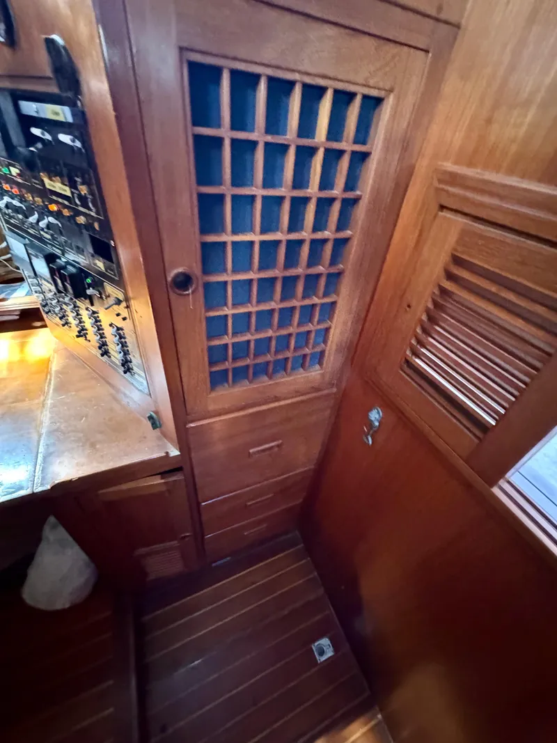 Slide: The Image of 1983 Tayana 52 Aft Cockpit interior with wooden cabinetry and control panel. - 35