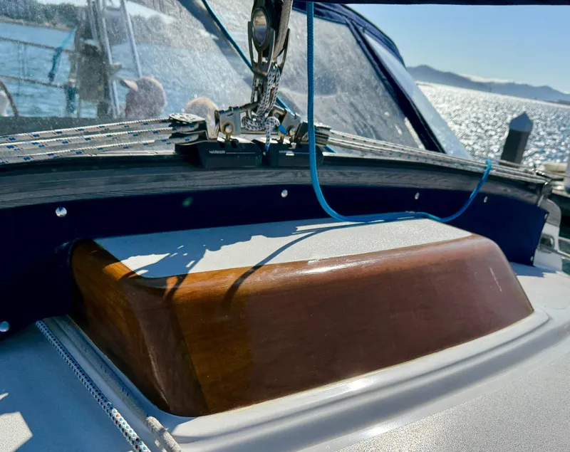 Slide: The Image of 1983 Tayana 52 Aft Cockpit sailboat detail with wooden hatch and ocean backdrop. - 46
