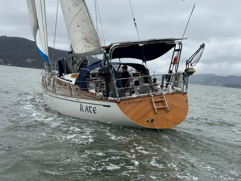 Slide: The Image of 1983 Tayana 52 Aft Cockpit sailboat navigating on a cloudy day. - 5