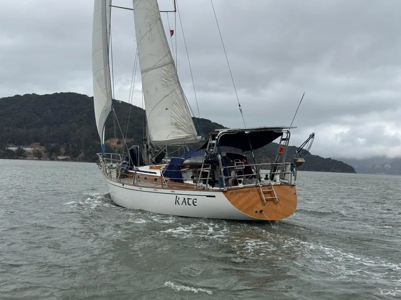 Slide: The Image of 1983 Tayana 52 Aft Cockpit sailboat navigating on a cloudy day. - 6