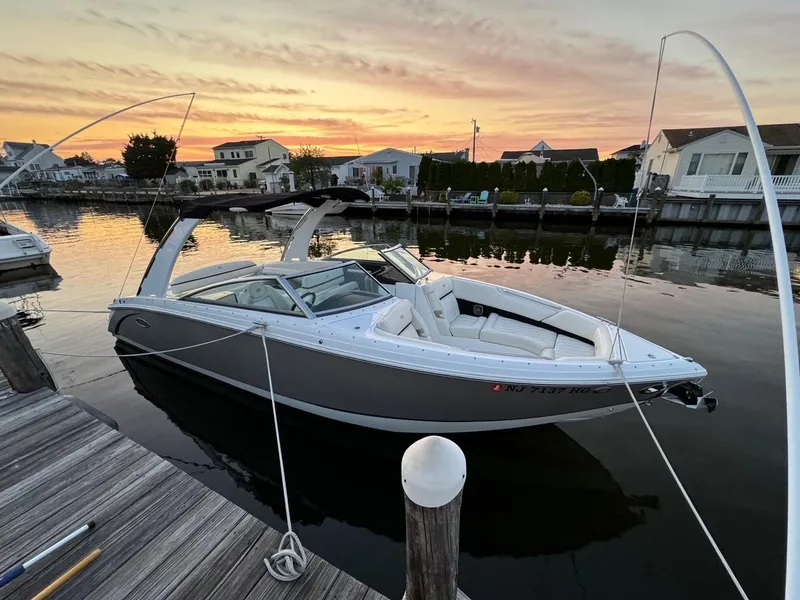 The Image of 2015 Cobalt R7 boat docked by waterfront homes under cloudy skies. - 0