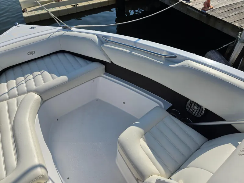 Slide: The Image of 2015 Cobalt R7 boat interior with white leather seating at a dock. - 15