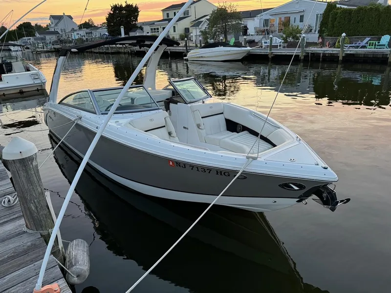 Slide: The Image of 2015 Cobalt R7 boat docked at sunset in a serene marina setting. - 2