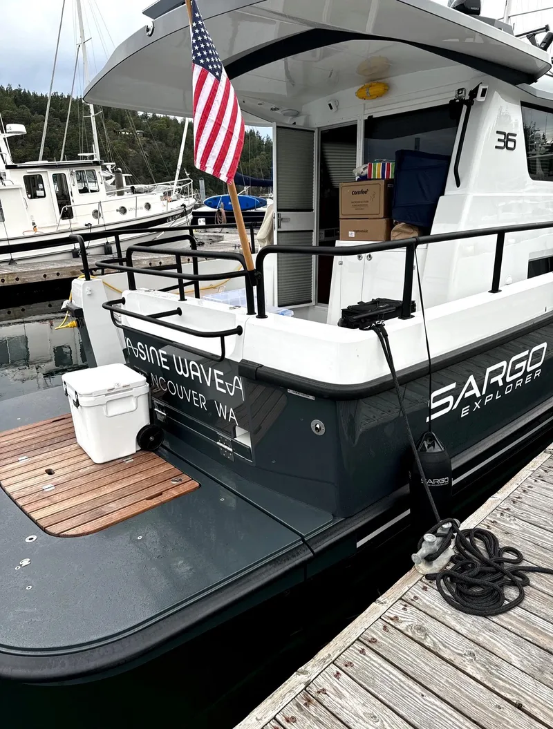 Slide: The Image of 2024 Sargo 36 Explorer docked, displaying American flag and nautical equipment. - 12