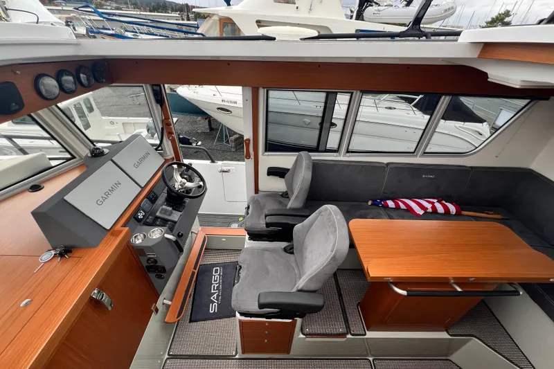 Slide: The Image of Interior of 2024 Sargo 36 Explorer boat with helm, seating, and wooden table. - 42