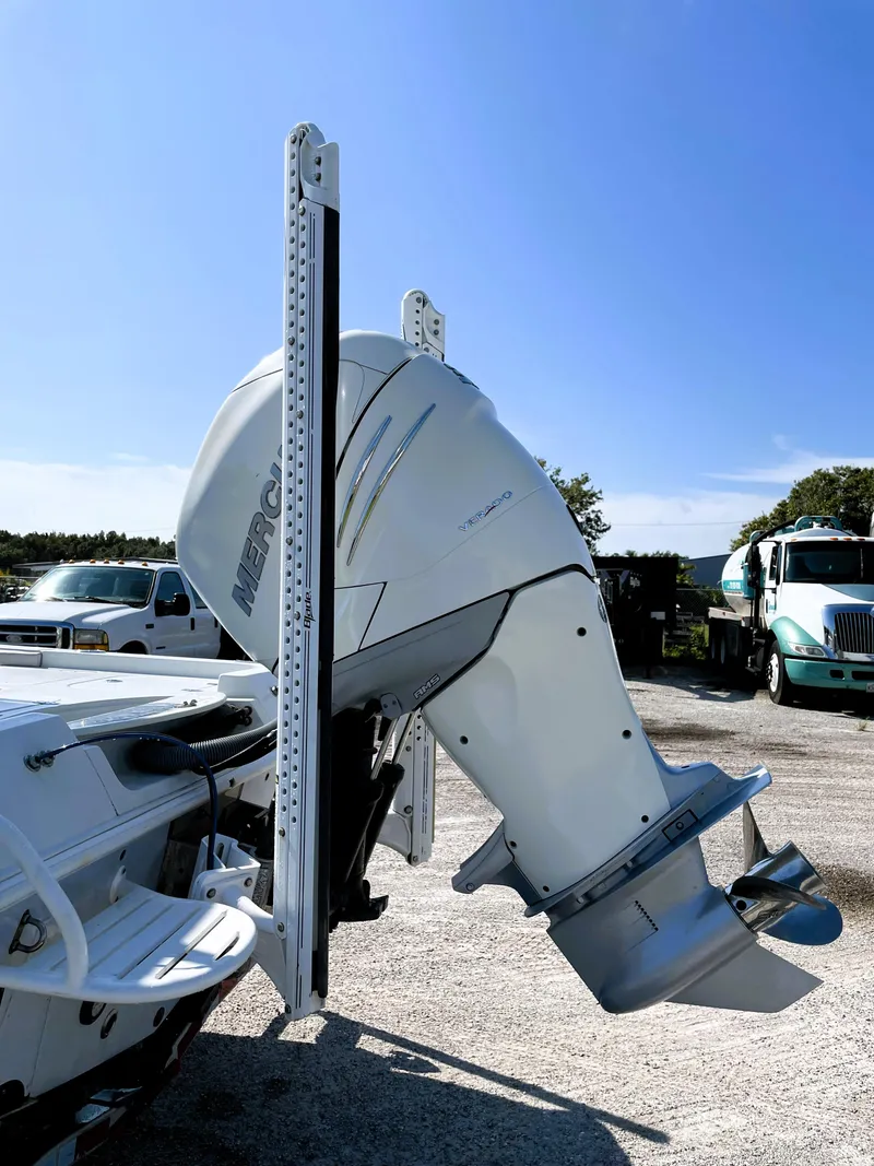 Slide: The Image of 2015 Contender 25 Bay boat with Mercury outboard motor, parked outdoors. - 13
