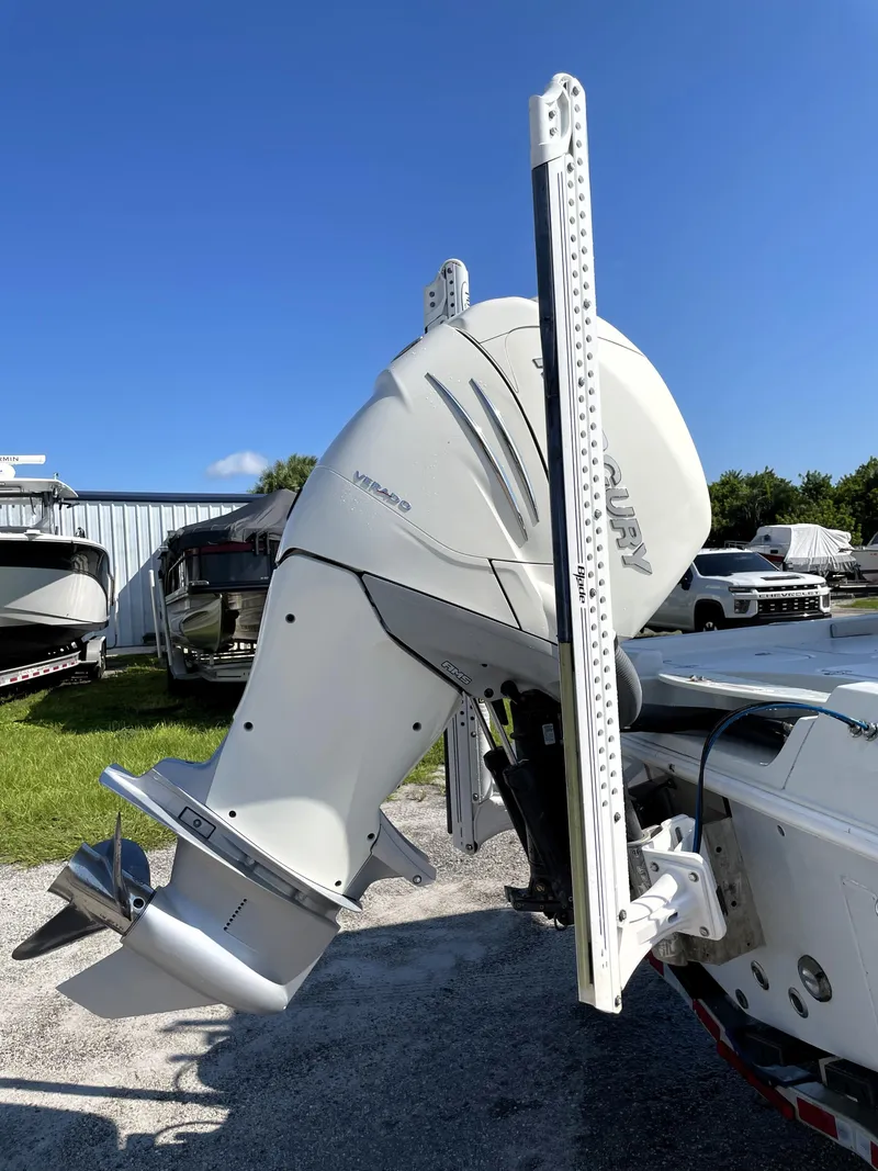Slide: The Image of 2015 Contender 25 Bay boat with outboard motor, parked outdoors. - 14