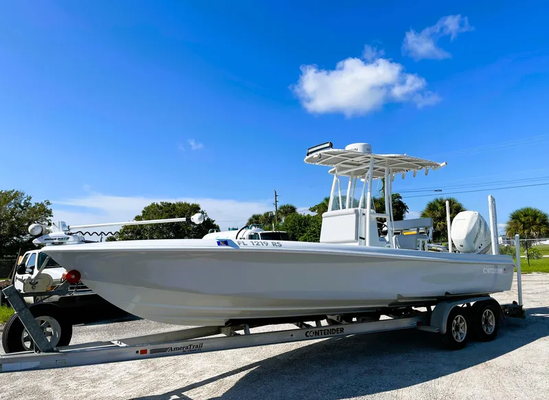 Slide: The Image of 2015 Contender 25 Bay boat on trailer under clear blue sky. - 2