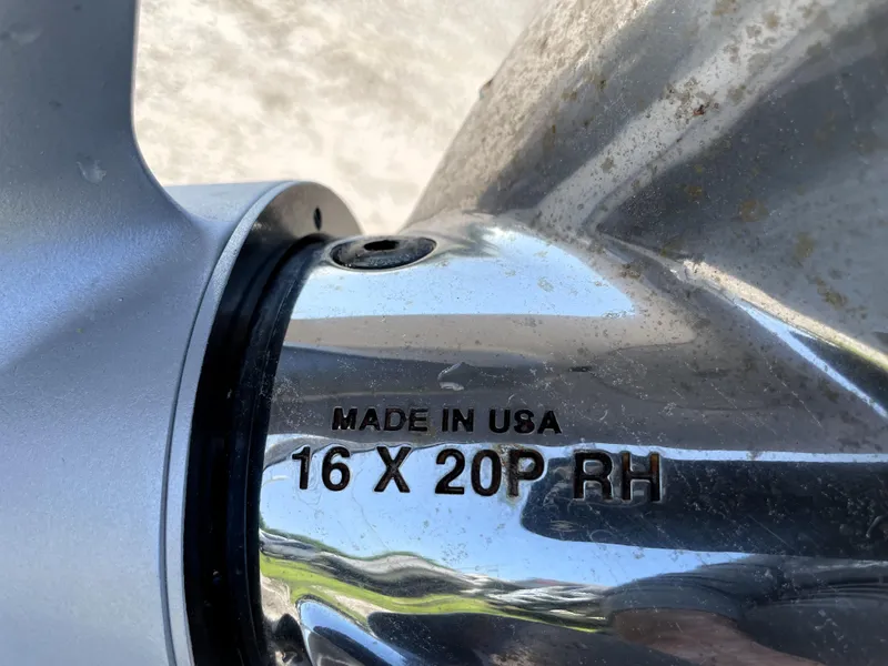 Slide: The Image of Close-up of a Contender 25 Bay 2015 boat propeller, marked "Made in USA 16 X 20P RH". - 20