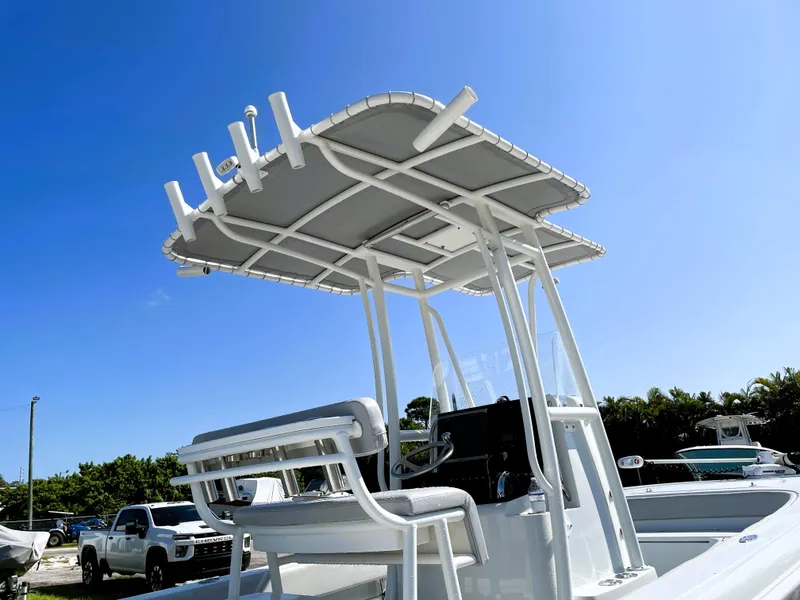 Slide: The Image of 2015 Contender 25 Bay boat with T-top and seating, under clear blue sky. - 21