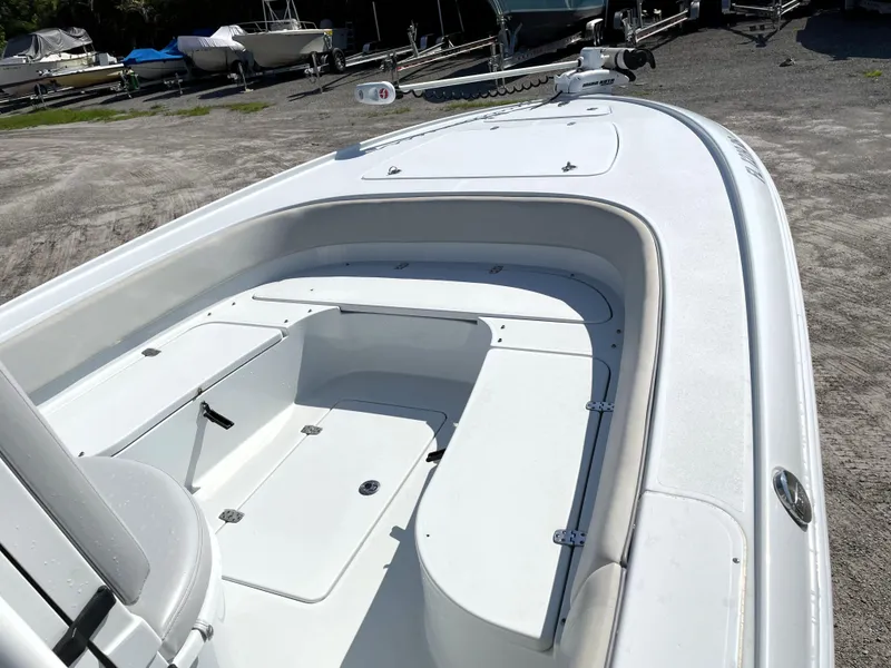 Slide: The Image of 2015 Contender 25 Bay boat, white deck, spacious seating, parked on gravel lot. - 26