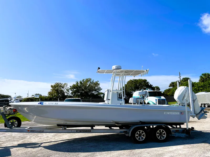 Slide: The Image of 2015 Contender 25 Bay boat on trailer under clear blue sky. - 3