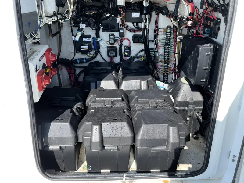 Slide: The Image of 2015 Contender 25 Bay boat electrical compartment with multiple battery boxes and wiring. - 43
