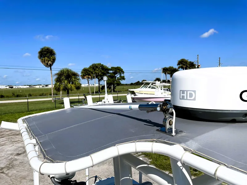 Slide: The Image of 2015 Contender 25 Bay boat with radar, clear sky, and palm trees in the background. - 48