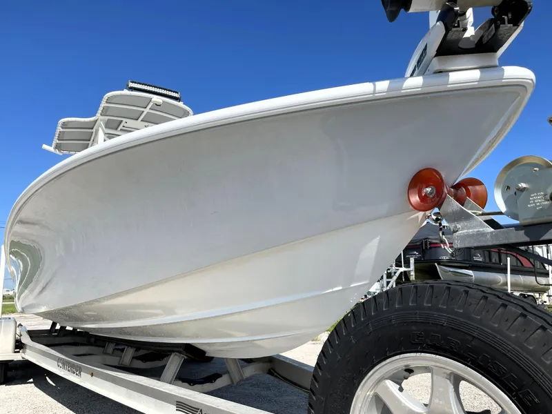 Slide: The Image of 2015 Contender 25 Bay boat on trailer under clear blue sky. - 8