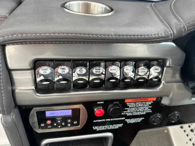 Slide: The Image of Control panel of 2016 Formula 330 Crossover Bowrider with labeled switches and cup holder. - 10