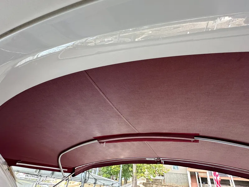 Slide: The Image of 2016 Formula 330 Crossover Bowrider with maroon canopy and sleek design. - 35