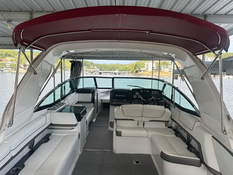 Slide: The Image of 2016 Formula 330 Crossover Bowrider with spacious seating and canopy, docked on a sunny day. - 38