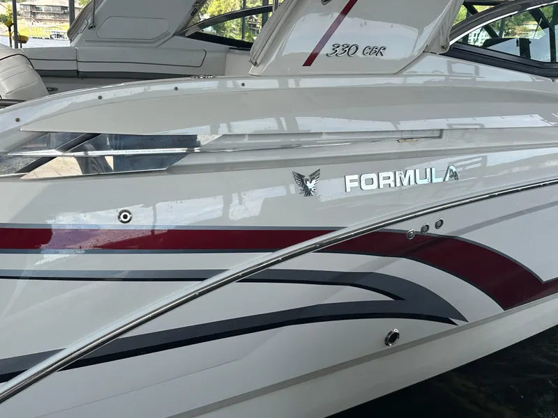 Slide: The Image of 2016 Formula 330 Crossover Bowrider boat with sleek design and red accents. - 43
