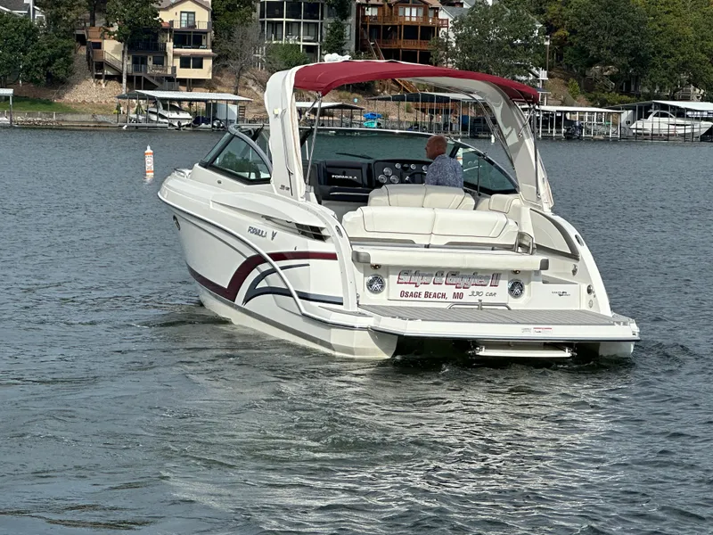 Slide: The Image of 2016 Formula 330 Crossover Bowrider on a lake, featuring sleek design and red canopy. - 47