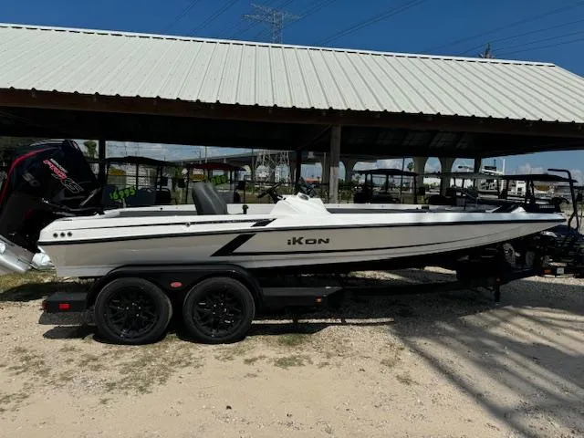 The Image of 2025 iKon VLX21 boat on trailer outside a warehouse under a cloudy sky. - 1