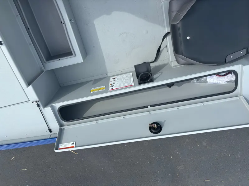 Slide: The Image of 2025 Crestliner 1600 Storm boat storage compartment with open lid and seat. - 1