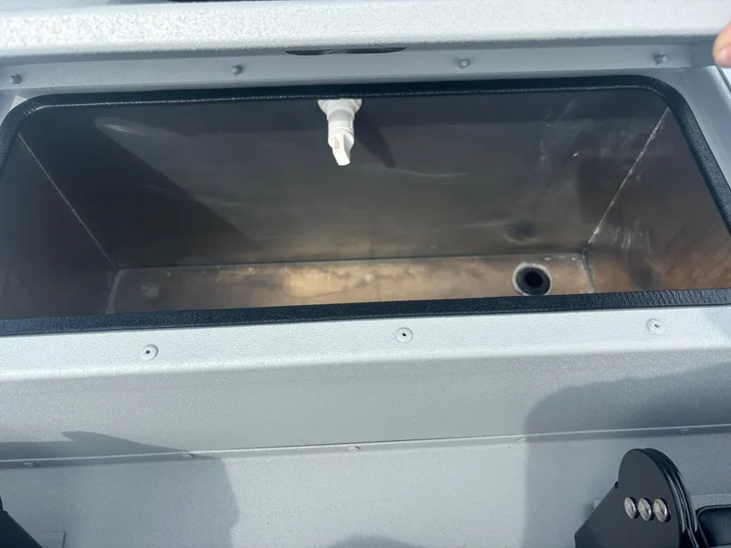 Slide: The Image of 2025 Crestliner 1600 Storm livewell interior with drain and faucet. - 2