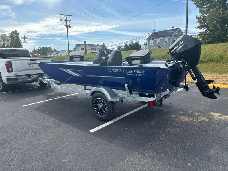 Slide: The Image of 2025 Crestliner 1600 Storm boat on trailer, parked beside a truck. - 7