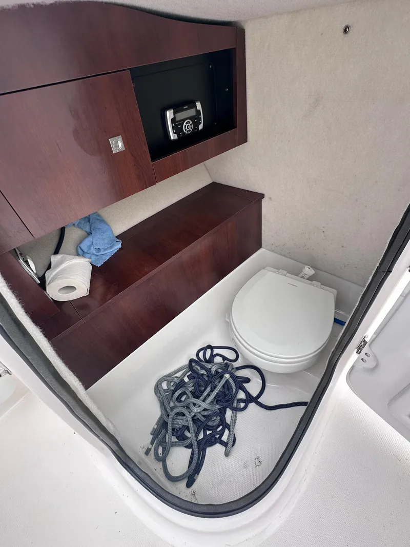 Slide: The Image of 2018 Robalo R227 Dual Console boat interior with toilet and storage cabinet. - 6