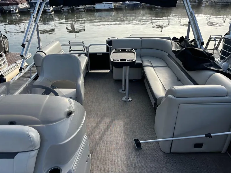 Slide: The Image of 2020 Sweetwater SW 2186 SB pontoon boat interior with seating and table, docked by the water. - 11