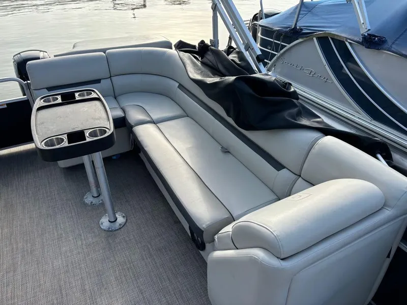 Slide: The Image of 2020 Sweetwater SW 2186 SB pontoon boat with gray seating and table, docked by water. - 15