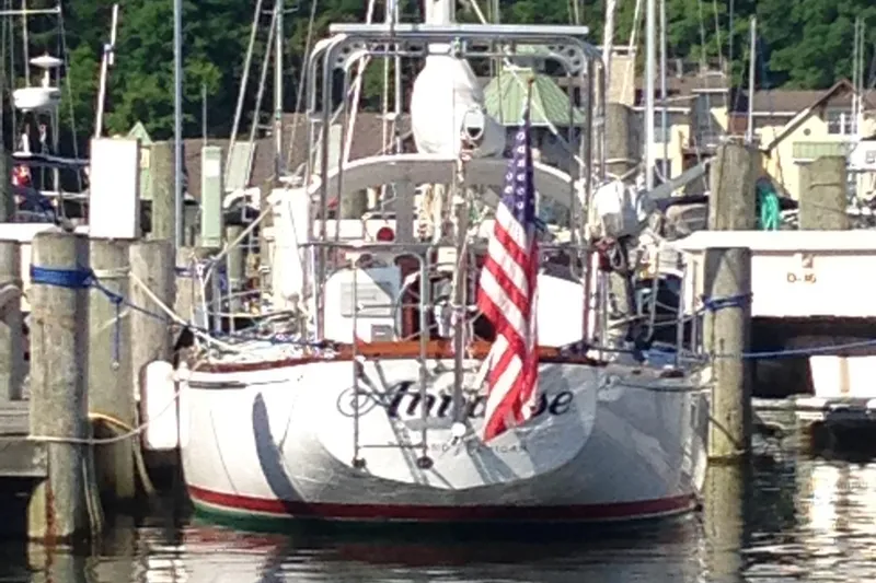 Slide: The Image of 1974 Tartan 34C sailboat docked with American flag, marina background. - 4