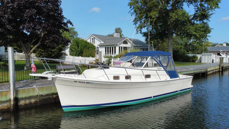 Slide: The Image of 2005 Mainship Pilot 30-II Sedan docked by a waterfront home. - 10
