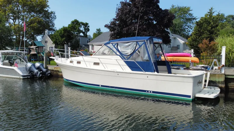 Slide: The Image of 2005 Mainship Pilot 30-II Sedan boat docked in a scenic marina. - 11