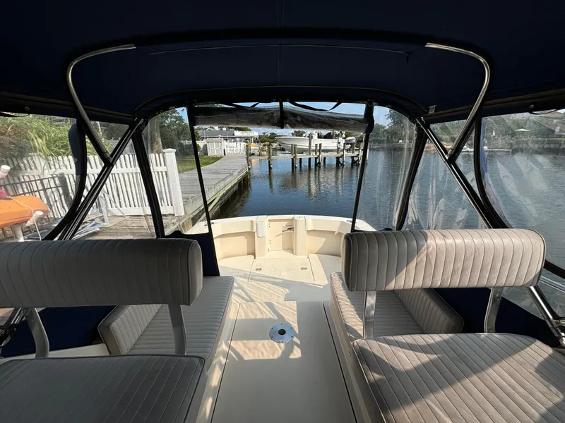Slide: The Image of 2005 Mainship Pilot 30-II Sedan interior view, featuring dockside seating and waterway. - 16