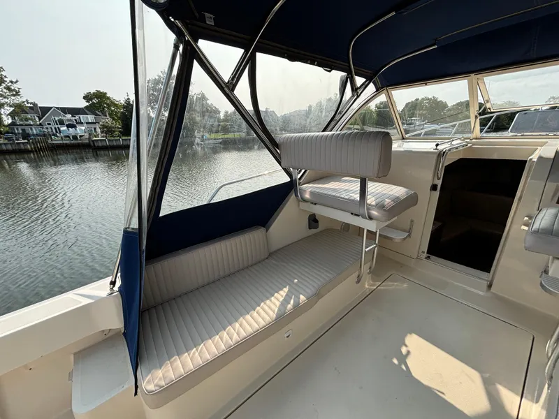 Slide: The Image of 2005 Mainship Pilot 30-II Sedan interior with seating, overlooking serene waterway. - 18