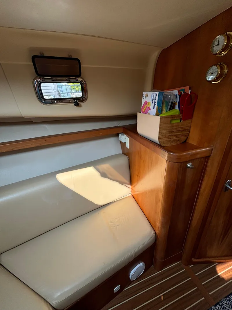 Slide: The Image of 2005 Mainship Pilot 30-II Sedan interior with beige seating and wooden accents. - 28