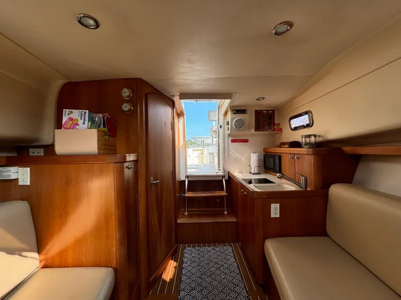 Slide: The Image of 2005 Mainship Pilot 30-II Sedan interior with wood finish and compact kitchen area. - 29