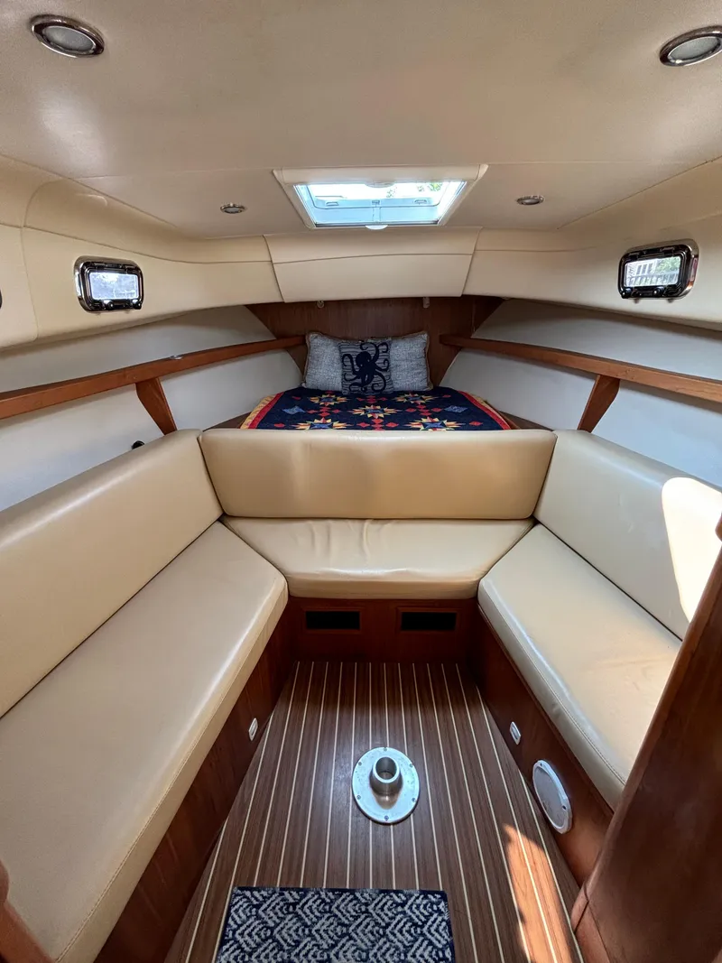Slide: The Image of 2005 Mainship Pilot 30-II Sedan cabin with beige seating and wood flooring. - 33