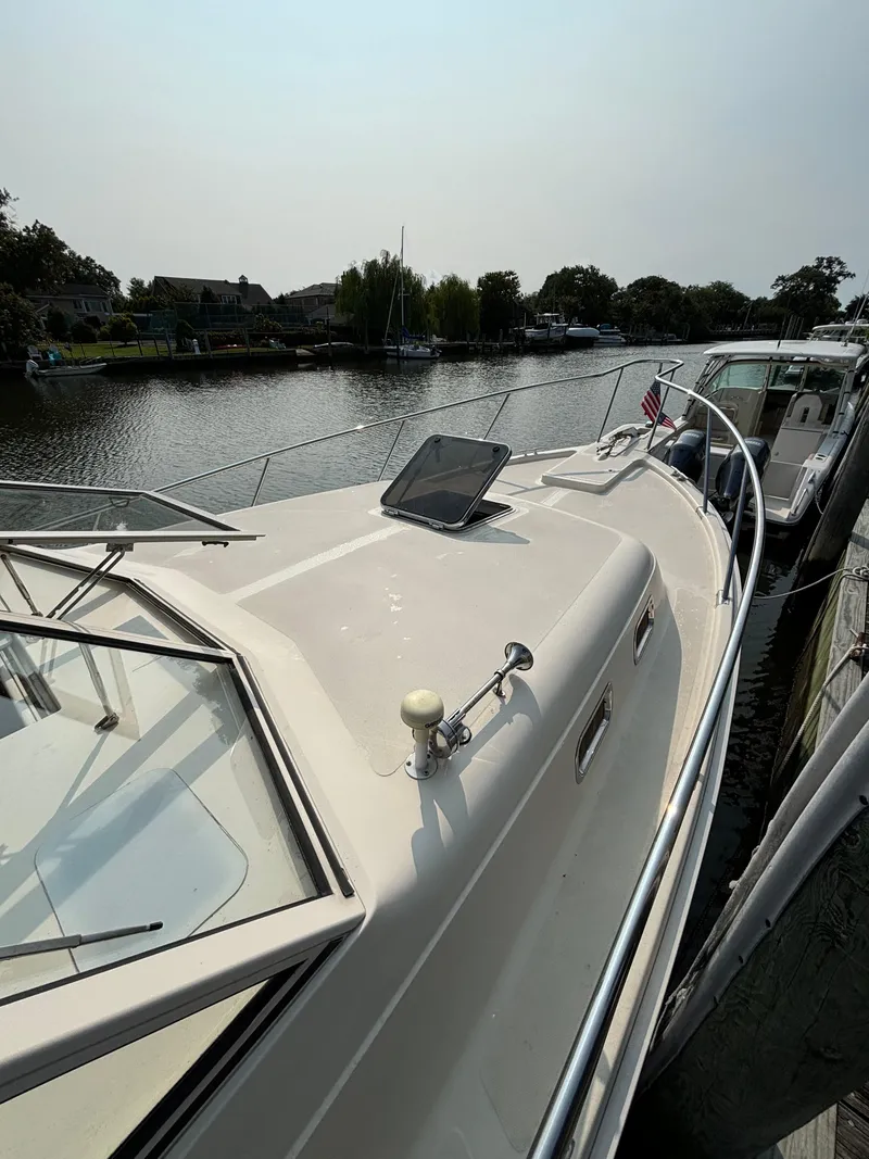 Slide: The Image of 2005 Mainship Pilot 30-II Sedan docked by a serene waterfront. - 35