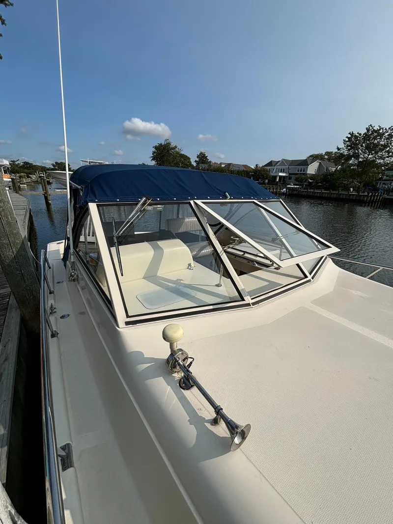 Slide: The Image of 2005 Mainship Pilot 30-II Sedan boat docked by a serene waterfront. - 36