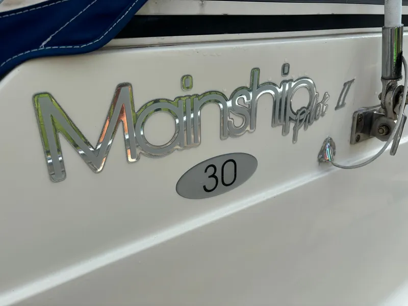 Slide: The Image of Mainship Pilot 30-II Sedan 2005 boat logo on white hull. - 38